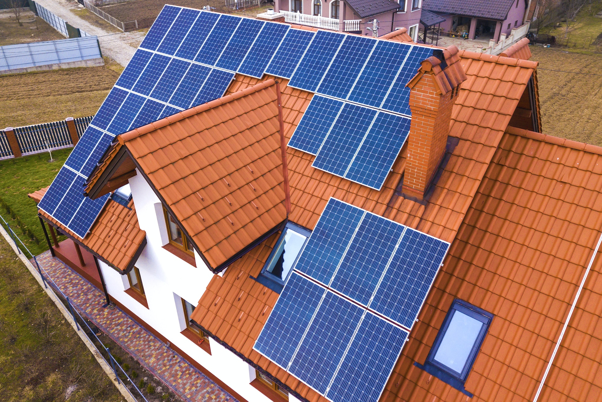 Aerial top view of new modern residential house cottage with blue shiny solar photo voltaic panels